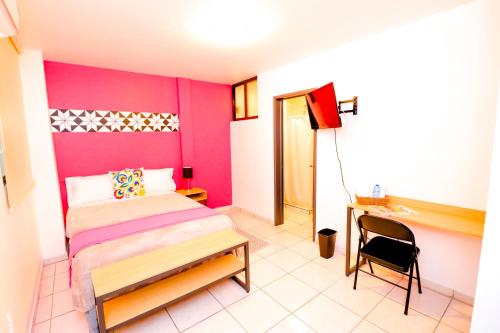a bedroom with a bed and a desk and a chair at Hotel Casa Blanca Minero in Fresnillo de González Echeverría