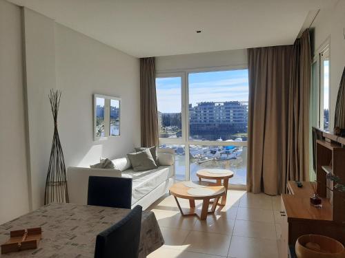 un soggiorno con divano e una grande finestra di Departamentos Condominio Wyndham Nordelta - Desayuno y Spa Opcional ! a Tigre