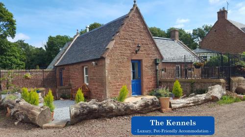 an old brick house with a blue door at Eco Indigo in Dunbar