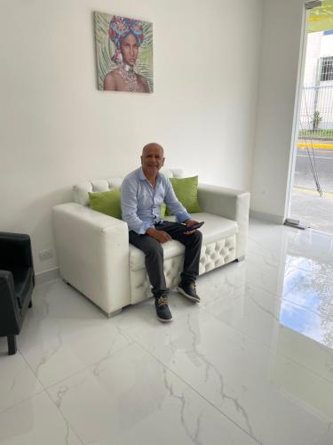 a man sitting on a couch in a living room at Hotel Sabana Inn in San José
