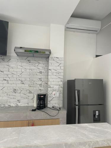a kitchen with a refrigerator and a counter top at Hotel Sabana Inn in San José