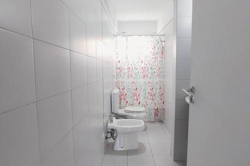 a bathroom with a toilet and a shower curtain at AT803 - Monoambiente Luminoso en Colegiales in Buenos Aires