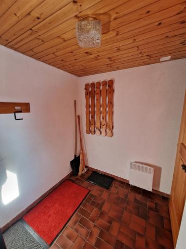 a room with a wooden ceiling and a red rug at Bettmeralp Chalet Zendorn in Bettmeralp
