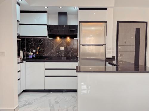 une cuisine avec des armoires blanches et des appareils en acier inoxydable dans l'établissement sharm luxury apartment in sharm hills, à Charm el-Cheikh