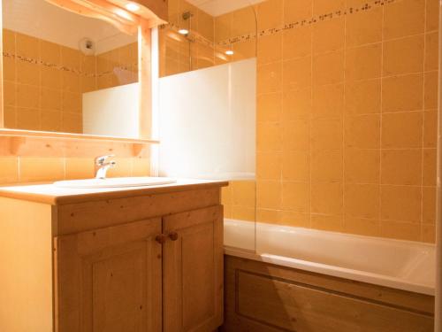 une salle de bain avec un lavabo, un miroir et une baignoire dans l'établissement Appartement 6 pers au pied des pistes, à côté des commodités et télécabine, Val Cenis - FR-1-508-6, à Lanslevillard
