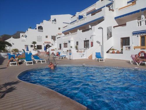 un hombre en una piscina frente a un edificio en Pool & View Christianos en Los Cristianos