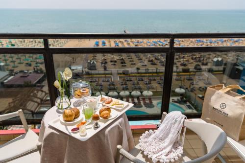 a table with food and a view of the ocean at Baia del Mar Beach Boutique Hotel in Lido di Jesolo