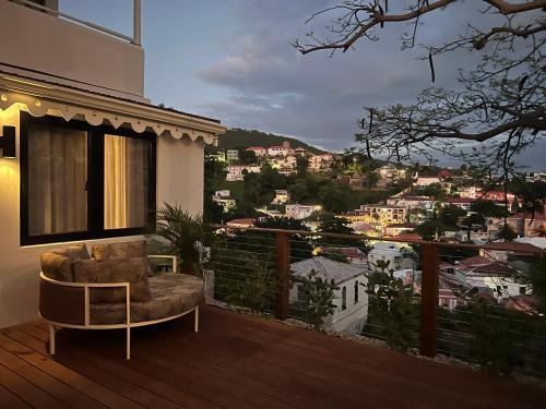 a balcony with a chair and a view of a city at The Pink Palm Hotel - Adults Only in Charlotte Amalie