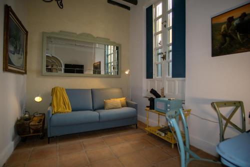 a living room with a blue couch and a mirror at Apartamentos Sharis in Jerez de la Frontera