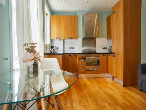 a kitchen with a glass table in a room at (Oxford Street - Piccadilly Circus) Apartment Central London in London