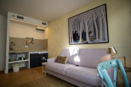 a living room with a couch and a kitchen at Apartamentos Sharis in Jerez de la Frontera