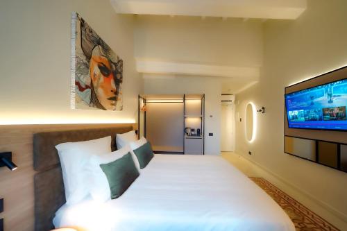 a hotel room with a bed and a flat screen tv at Bergamo INN 21 in Bergamo