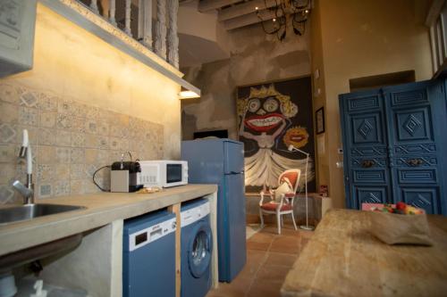 a kitchen with a blue refrigerator and a microwave at Apartamentos Sharis in Jerez de la Frontera