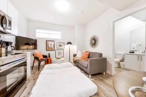 a white living room with a couch and a table at Cozy Nordic Utopia, Bsmt Suite near WEM & DT, King Bed, WiFi in Edmonton