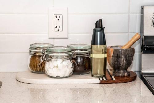 a counter with jars and a cutting board with spices at Cozy Nordic Utopia, Bsmt Suite near WEM & DT, King Bed, WiFi in Edmonton
