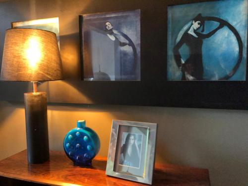 a lamp on a table with a picture and a picture frame at Hadley's Bed and Breakfast in Hamburg