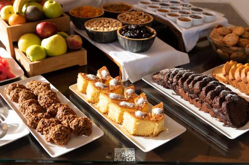 a table with different types of cakes and other desserts at Porto Kea Suites by Sandglass in Korissia