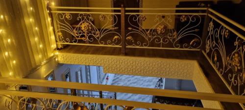 a balcony with a gold railing and a window at Hotel Guest House GOLDEN DEGREZ in Bukhara