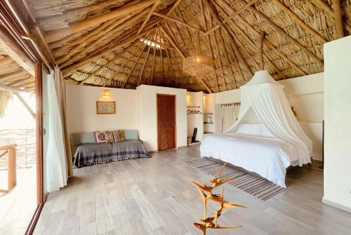 a bedroom with a bed and a wooden ceiling at Akalki Hotel y Centro Holistico in Bacalar