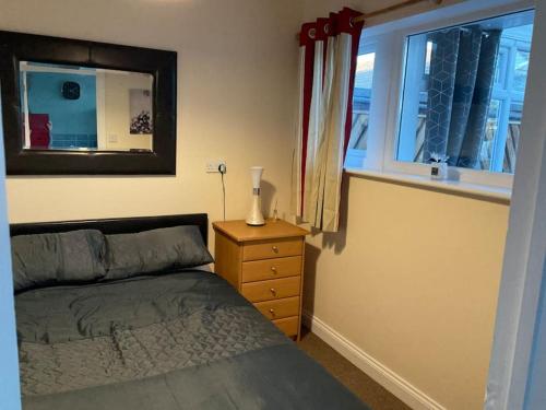 - une chambre avec un lit, un miroir et une fenêtre dans l'établissement Comfy and welcoming 2 bedroom Annex., à Padstow