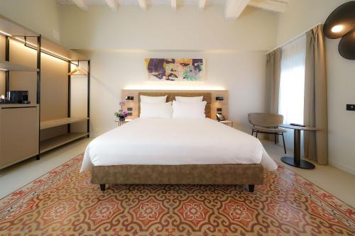 a large bedroom with a large white bed and a table at Bergamo INN 21 in Bergamo