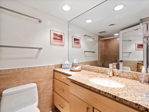 a bathroom with a sink and a toilet and a mirror at Ocean One 222 in Hilton Head Island