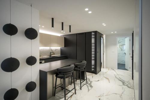cocina con taburetes y paredes en blanco y negro en Luxury Apartment Contesa, en Rovinj