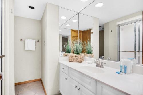 La salle de bains est pourvue d'un lavabo et d'un grand miroir. dans l'établissement Shoreline Towers Townhouse 4-4, à Destin