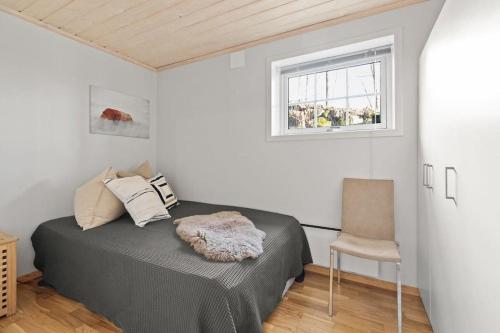 a bedroom with a bed and a window and a chair at Pretty appartment close to Oslo in Asker