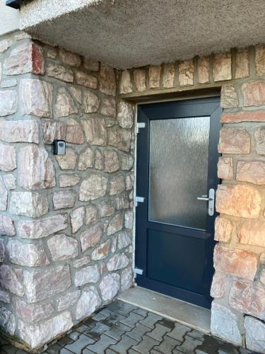 a black garage door in a stone wall at Benecko 138 in Benecko