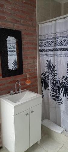 a bathroom with a sink and a shower curtain at Sierra Suites in Sierra de los Padres