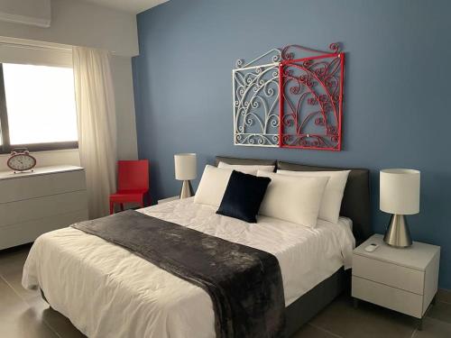 a bedroom with a large bed with a blue wall at Luxurious sunlit maisonette with large terrace! in Marsaskala