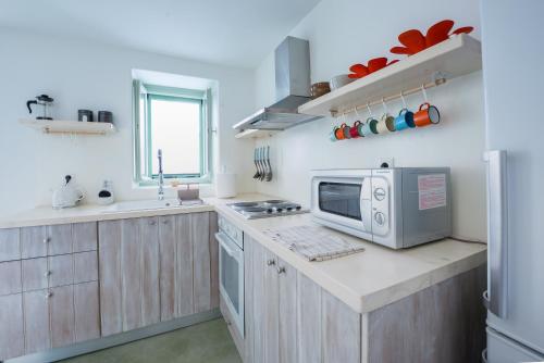 a kitchen with a microwave on a counter top at Stasa Aegina in Aegina Town
