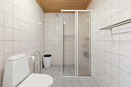 a white bathroom with a shower and a toilet at Pretty appartment close to Oslo in Asker