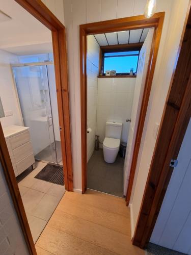 a bathroom with a toilet and a glass door at *The Hideaway* Lake Views/Bike Storage/Smart Home/Free WiFi in Jindabyne