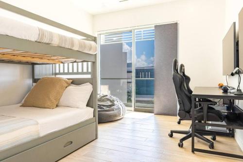 a bedroom with a bunk bed and a desk with a computer at Five Palms PENTHOUSE in George Town