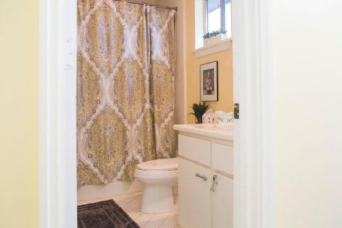 a bathroom with a toilet and a shower curtain at South Beach Lane 47 in Hilton Head Island