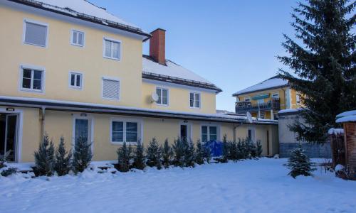 Una casa con árboles de Navidad en la nieve en Blue Line Apartements, en Arnoldstein