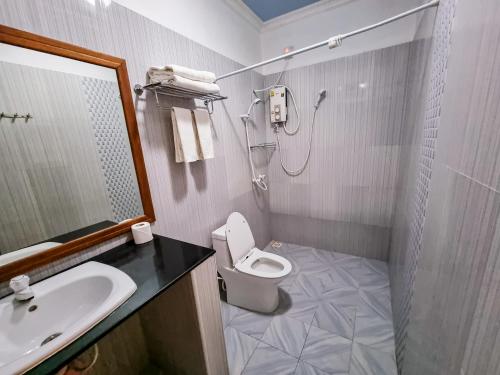 uma casa de banho com um lavatório, um WC e um chuveiro em Suvaasa Inn em Omadhoo