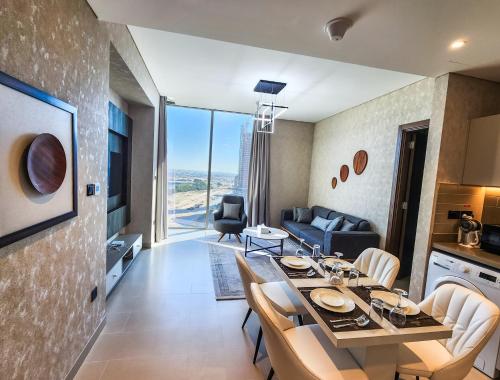 a dining room and living room with a table and chairs at STAY BY LATINEM Luxury 2BR Holiday Home CV B1614 near Burj Khalifa in Dubai