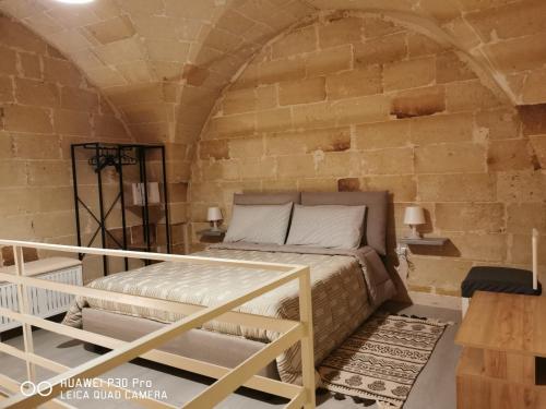 a bedroom with a bed in a brick wall at Appartamento Pittori in Manduria
