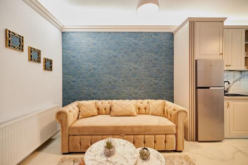 a living room with a couch and a refrigerator at UpTown Apartments in Iaşi