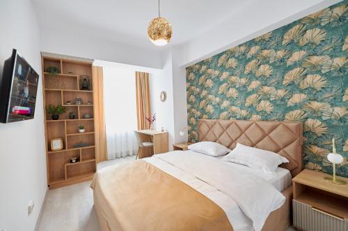 a bedroom with a large bed with a floral wallpaper at UpTown Apartments in Iaşi