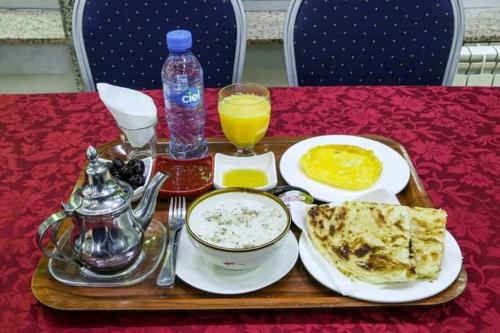 un vassoio con cibo e bevande su un tavolo di HOTEL LA POMME ZAIDA a Zeïda