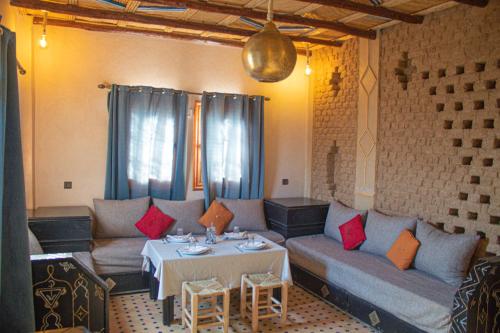 a living room with a couch and a table at Riad Hassi Labied Merzouga in Merzouga