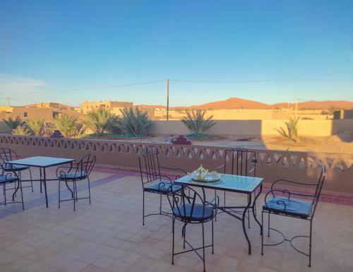 a group of tables and chairs on a patio at Riad Hassi Labied Merzouga in Merzouga