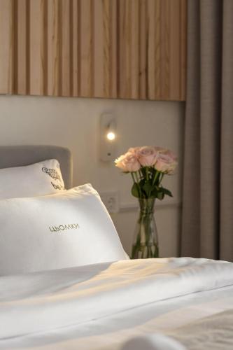 a bed with a vase with flowers in a room at be be Chalet - premium jacuzi & private pool in Bukovel