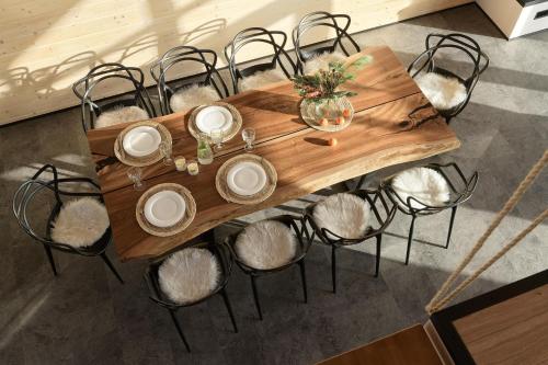 a wooden table with chairs around it with plates and candles at be be Chalet - premium jacuzi & private pool in Bukovel