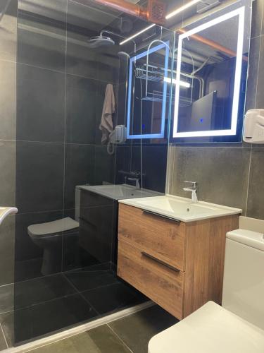 y baño con lavabo, aseo y espejo. en Ideal Apartment n4, en Pristina