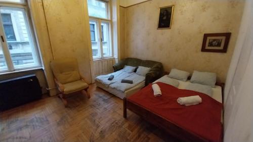 1 dormitorio con 2 camas, sofá y silla en Retro Rooms, en Budapest